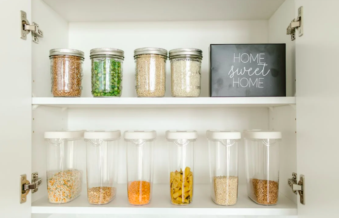 Picture of an organized cabinet with different foods in mason jar containers and tupperware containers